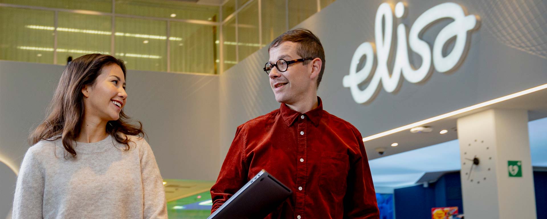 mies ja nainen kävelevät elisan toimistolla