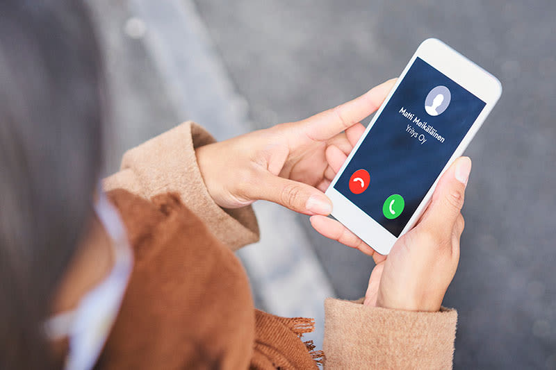 puhelin kädessä, näytöllä saapuva puhelu