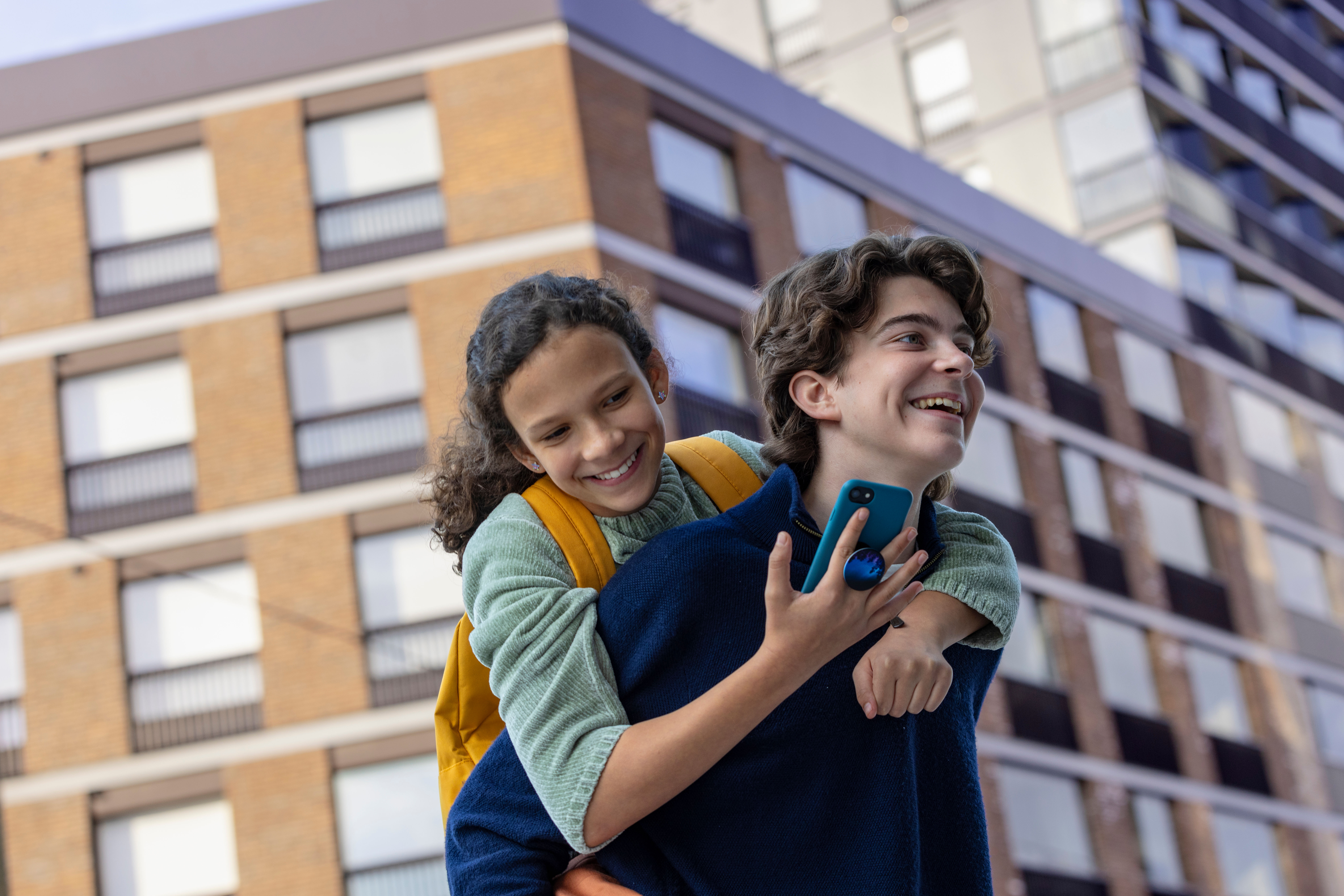 two young people watching phone outdoors