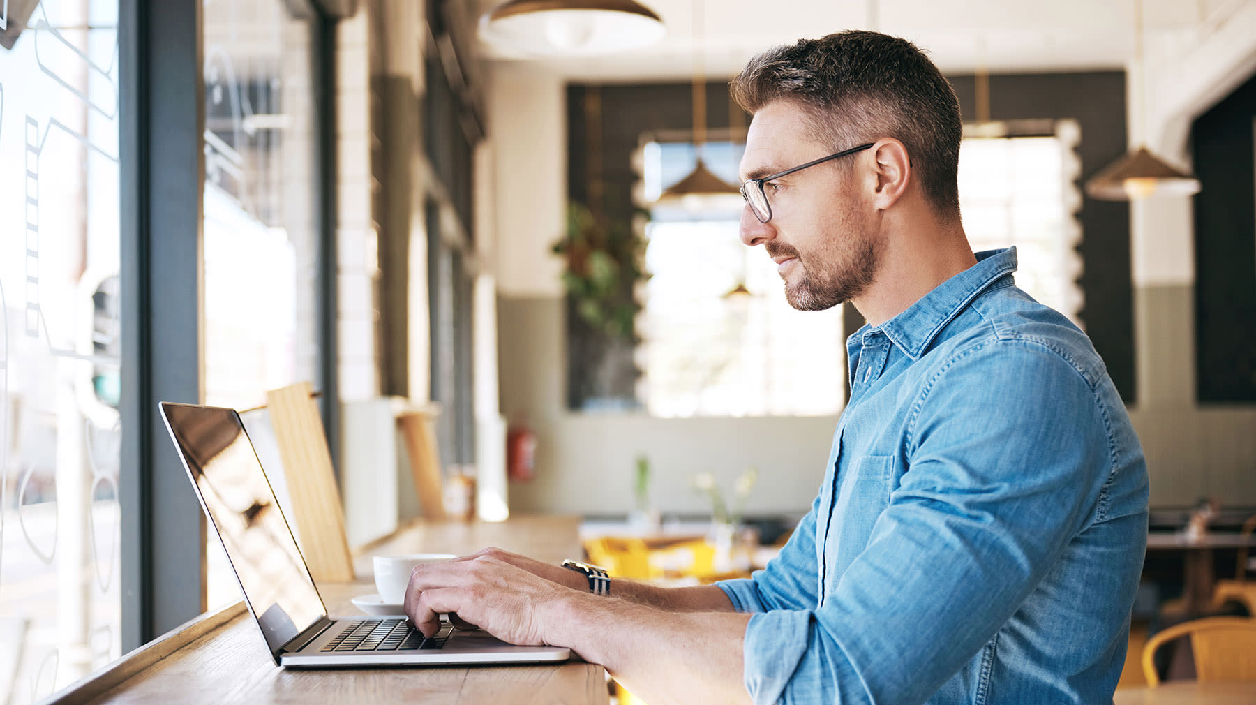 Vinkit kannettavan tietokoneen valintaan. Mies työskentelemässä tietokoneella.