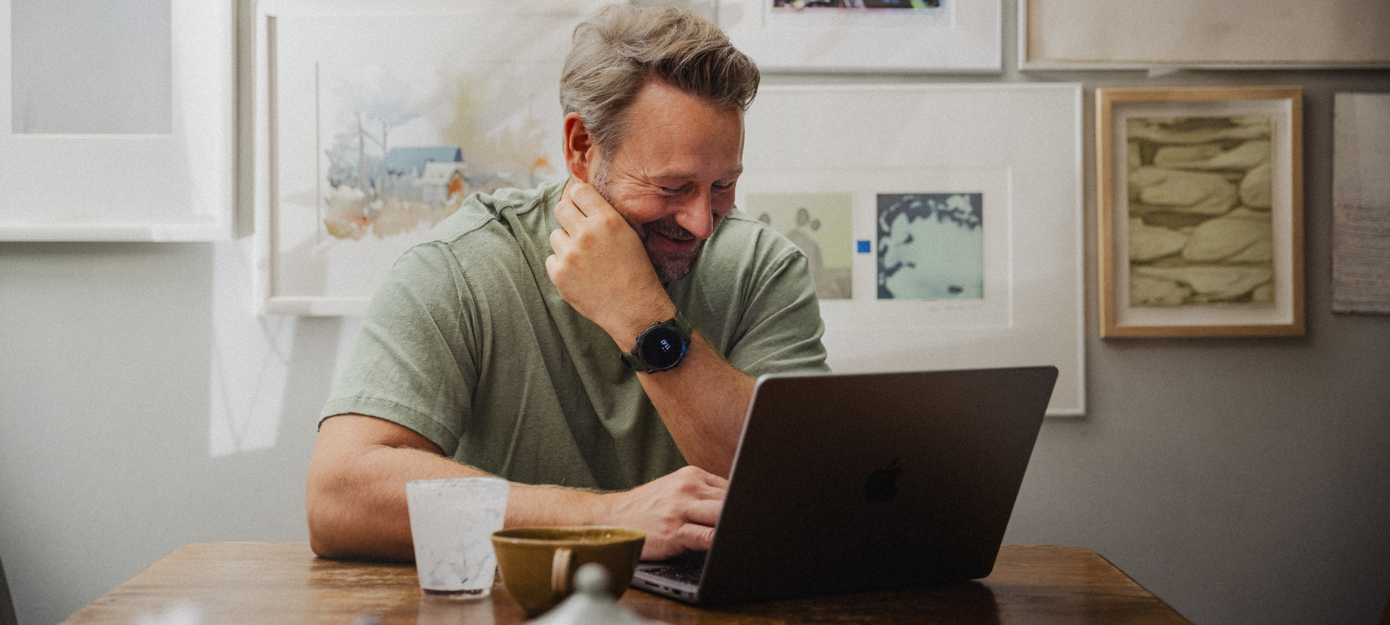 mies hymyillen läppärin äärellä