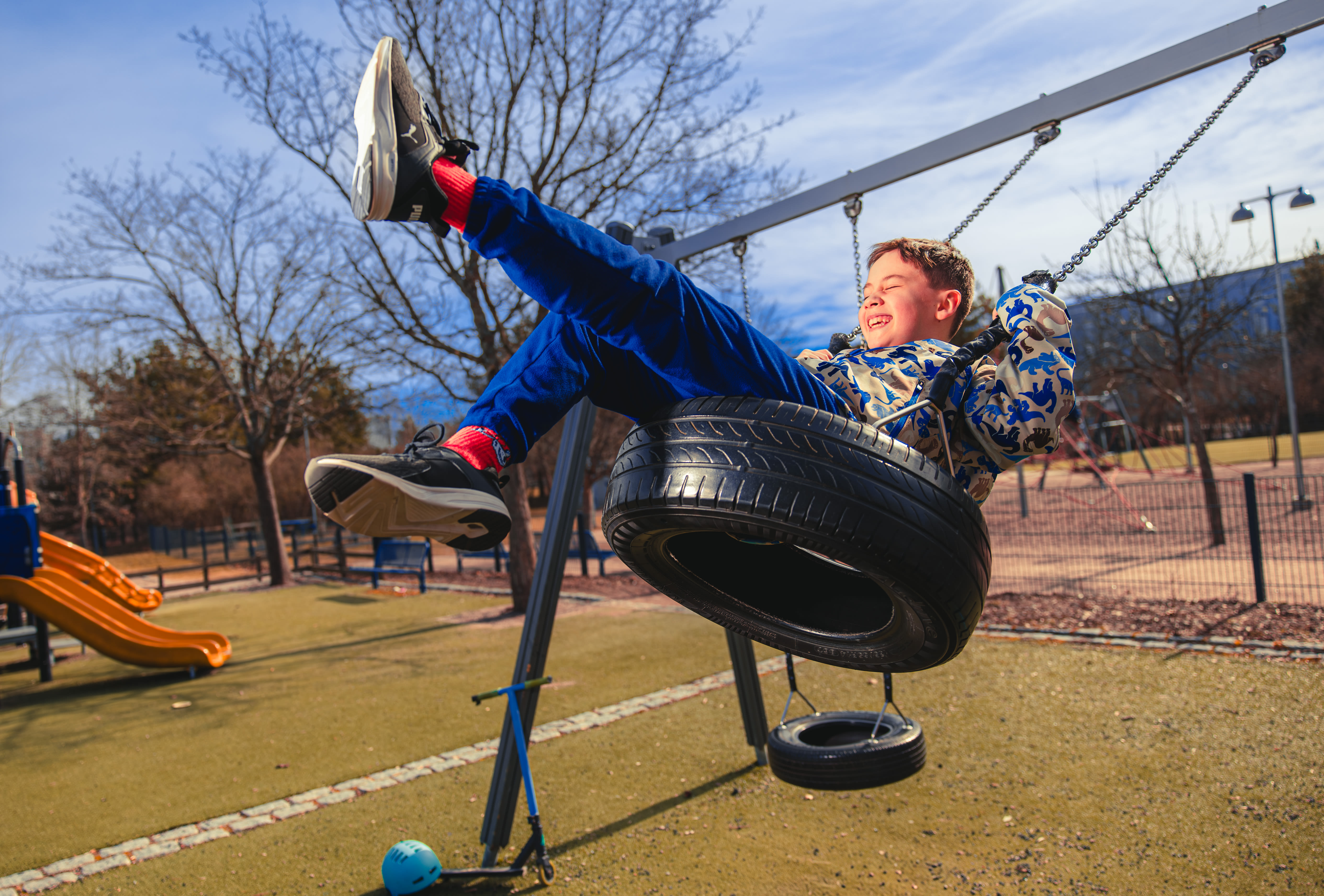 poika keinuu kovaa vauhtia leikkipuiston rengaskeinussa