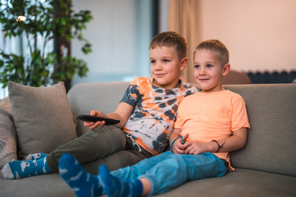 kaksi pikkupoikaa sohvalla televisiota katsomassa