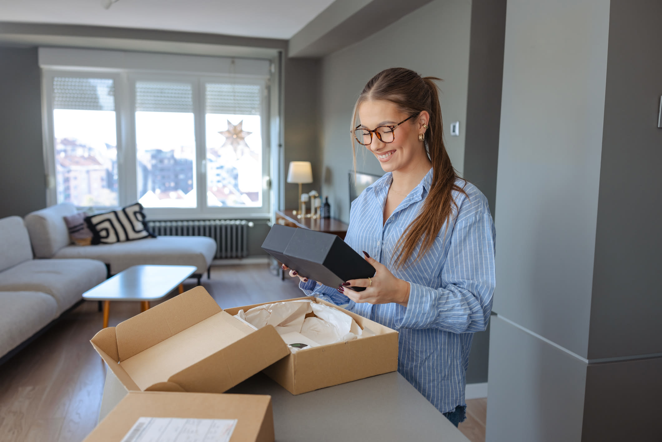 nainen avaamassa pakettia