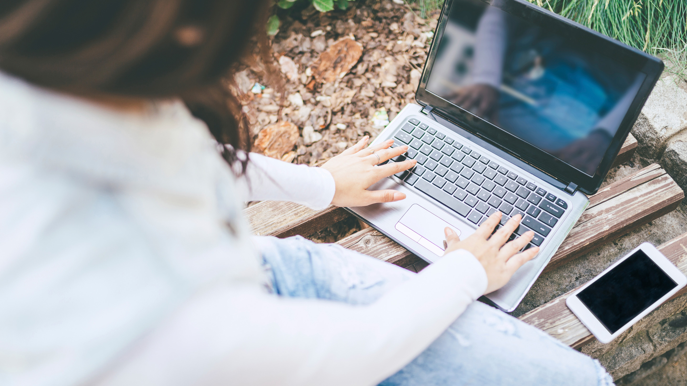 nainen kirjoittaa läppärillä ulkona