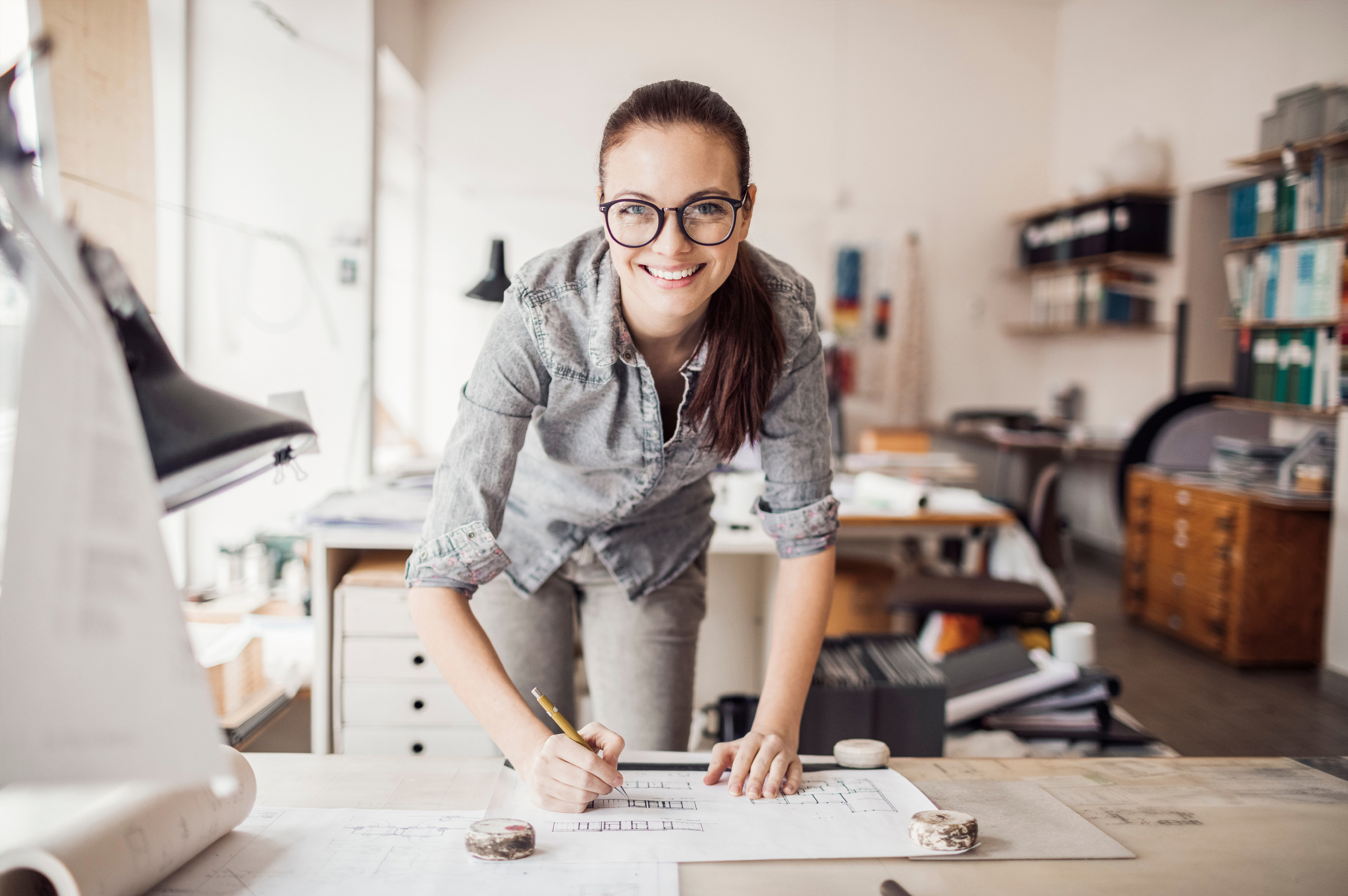 Hymyilevä nainen työnteossa.