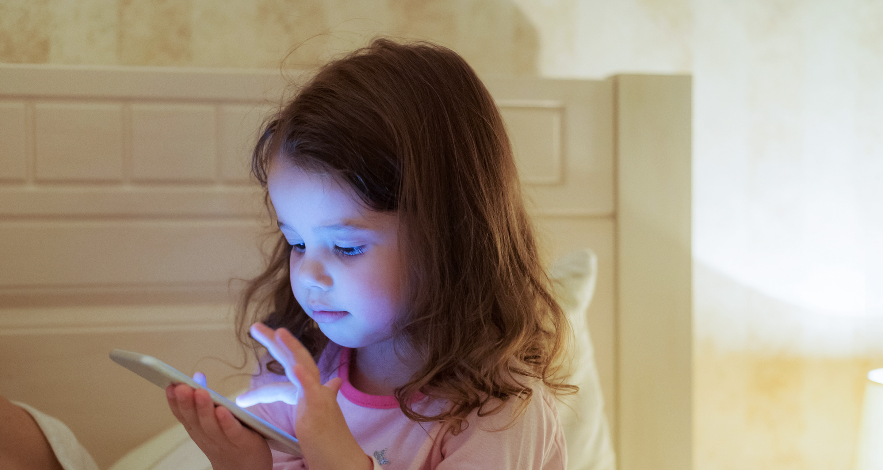 pikkutyttö tuijottamassa puhelimen ruutua