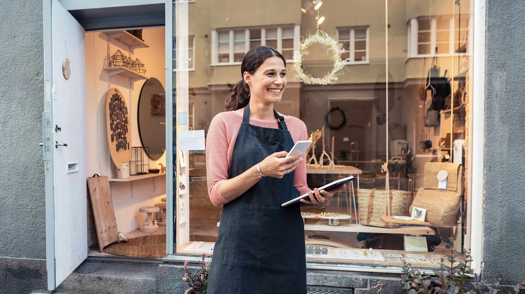 Keskihintaiset puhelimet esittelyssä. Nainen puhelin kädessään.