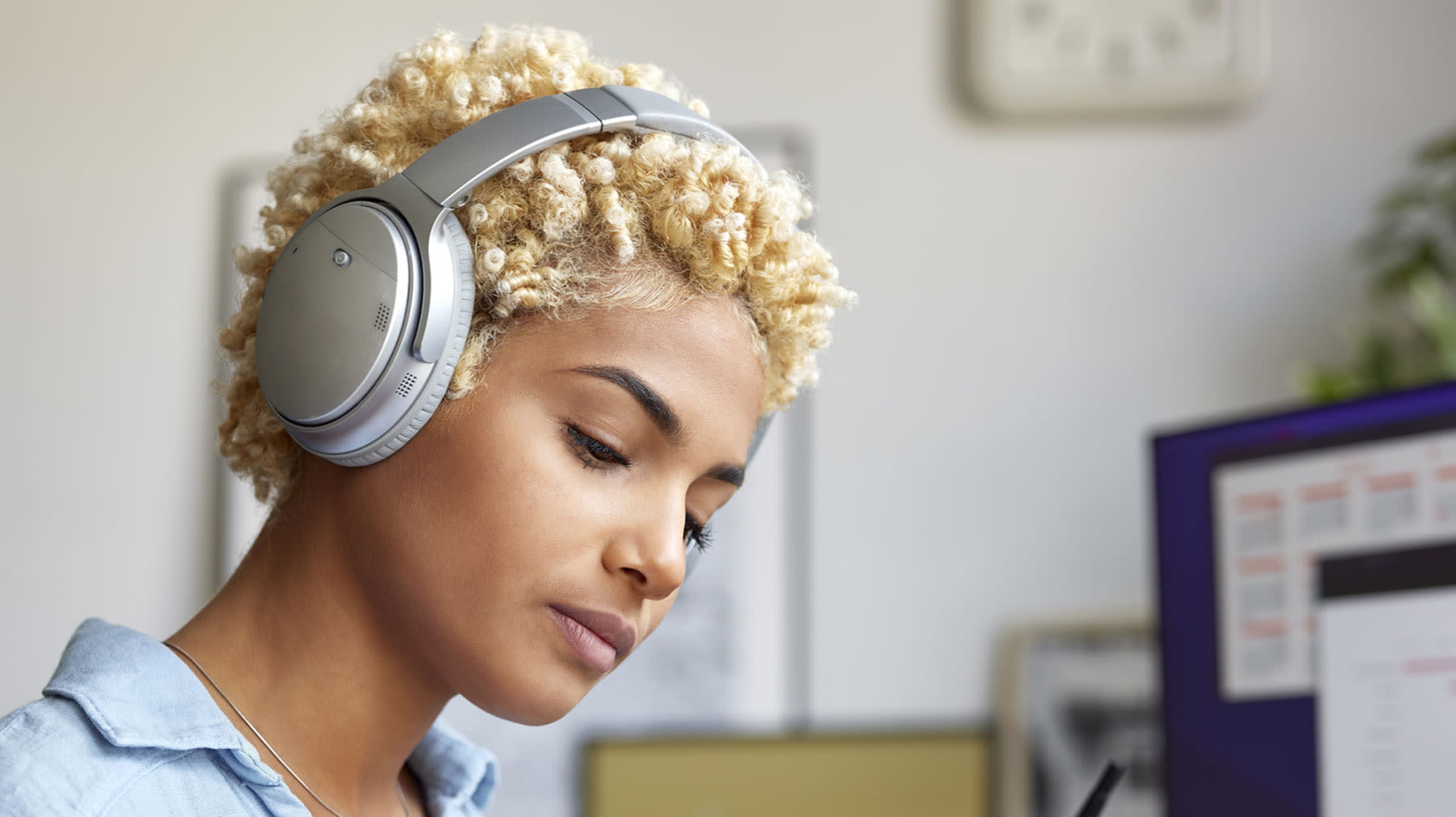 Nainen langattomat kuulokkeet päässään.