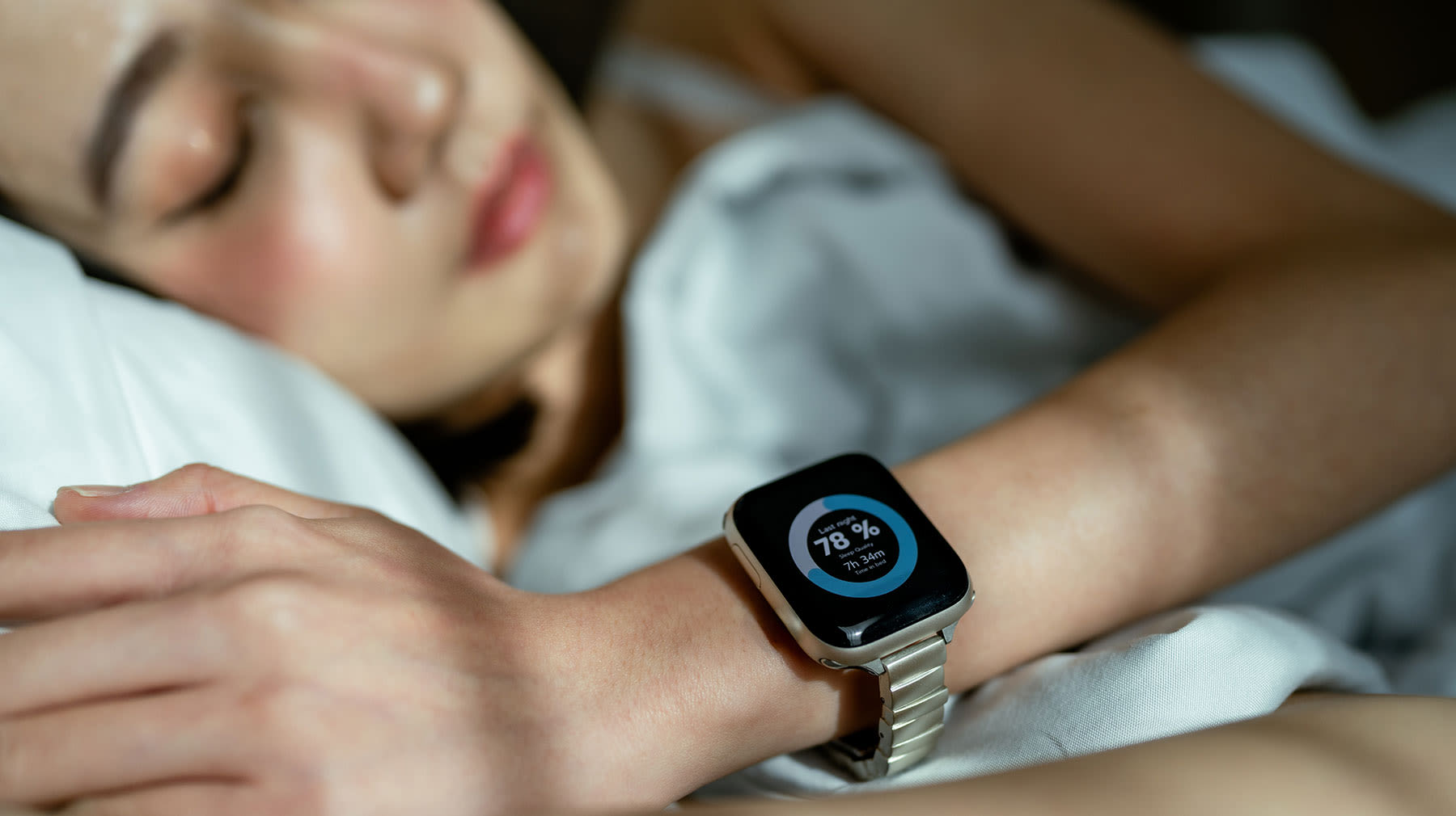 Nainen nukkuu. Ranteessa hänellä on älykello, joka seuraa unen vaiheita.