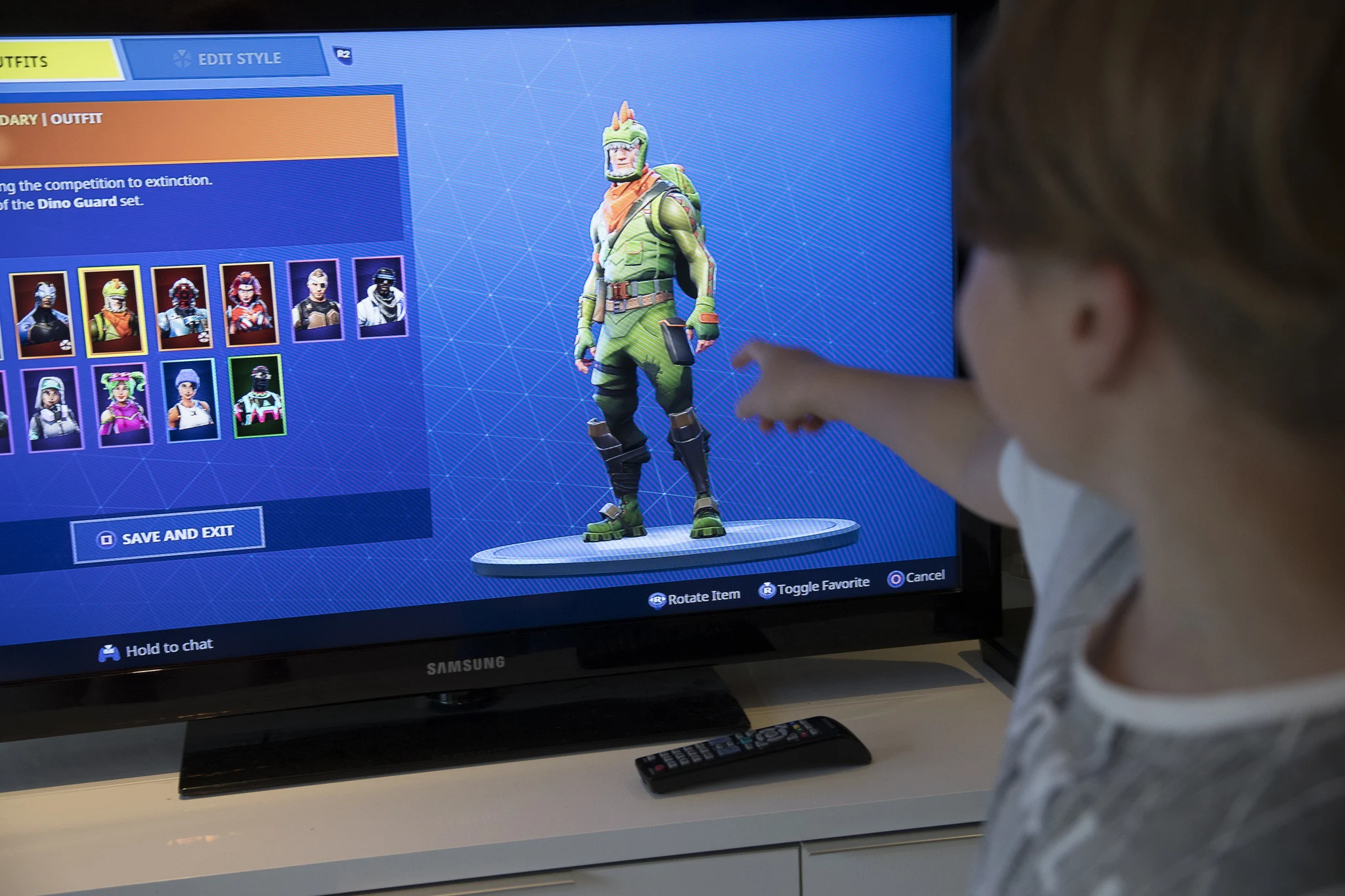 Poika osoittaa fortnite-pelihahmoa television ruudulta