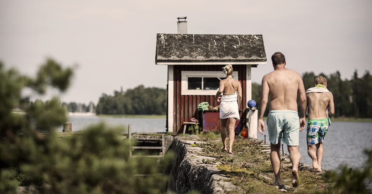 Perhe kävelee kohti rantaa mökillä. Paras netti mökille.