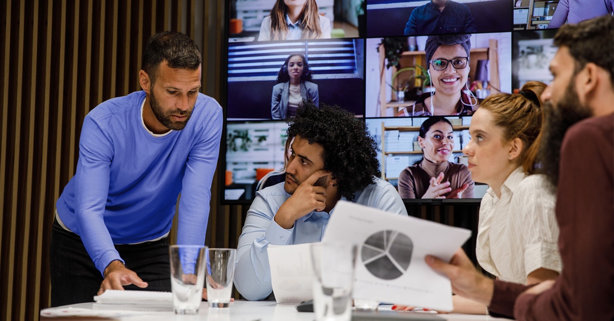 Ihmiset työskentelvät pöydän ääressä. Miten digitaalinen työpaikka rakennetaan?