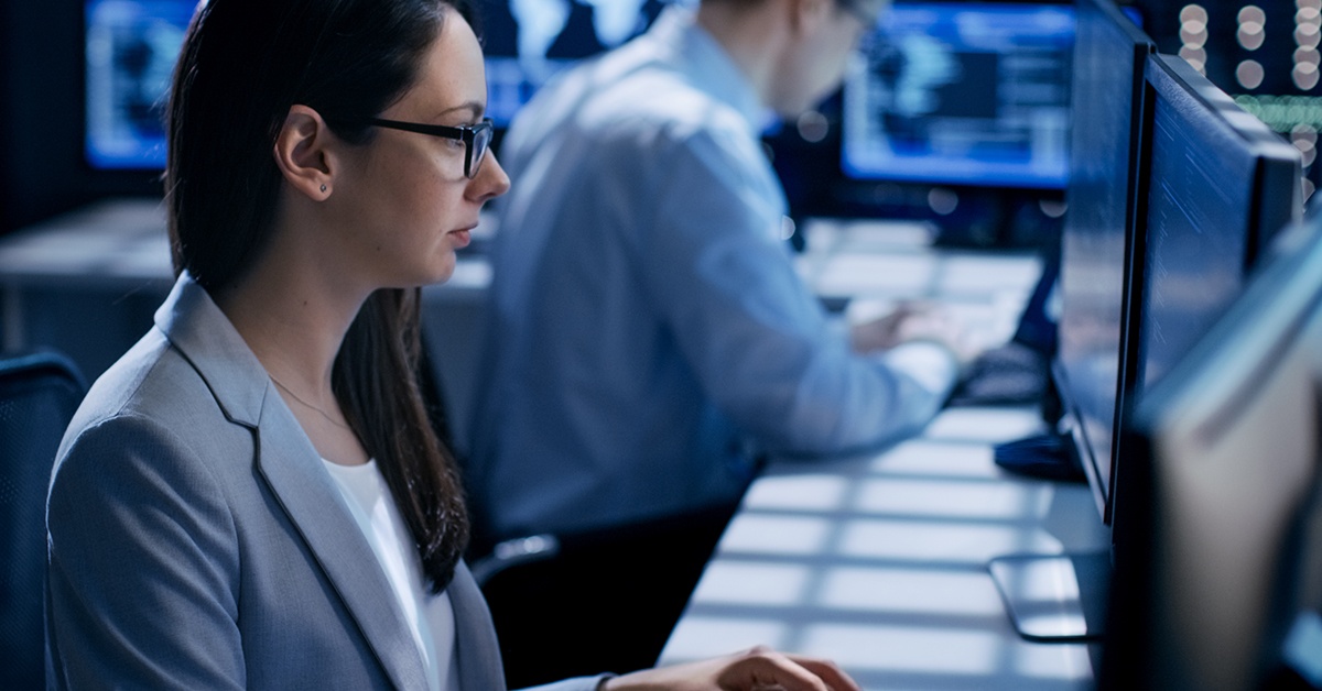 Nainen työskentelee tietokoneella ja katsoo näyttöä. Kyberharjoitukset.