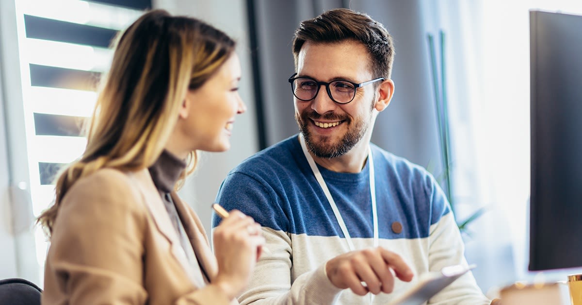 Hymyilevät nainen ja mies työskentelevät tietokoneen ääressä. G.fast-liittymä.