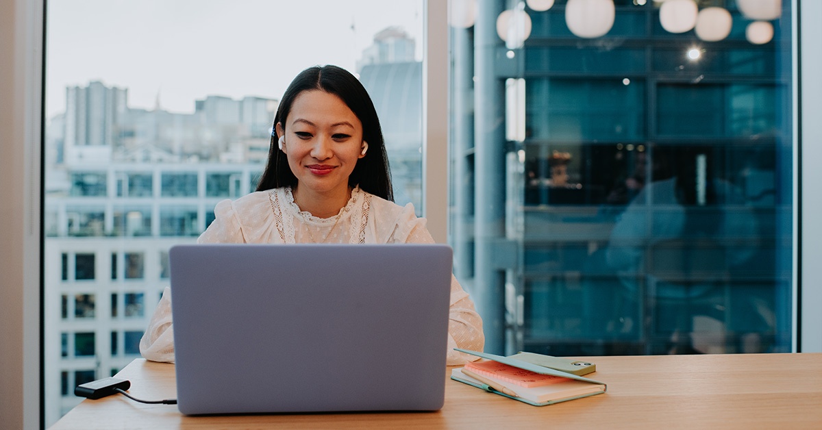 Nainen työskentelee tietokoneella toimistolla. SASE-ratkaisu.