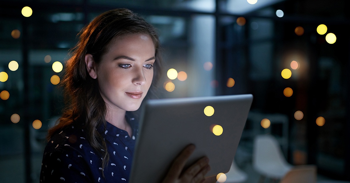 Nainen katsoo tablettia. CX Akatemia.