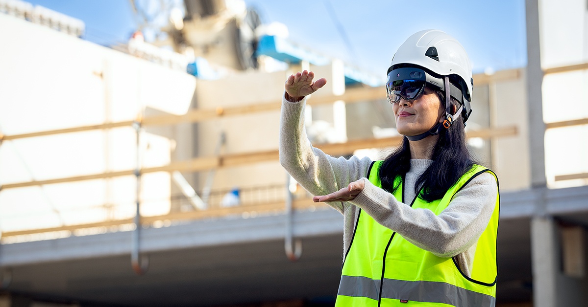 Nainen seisoo rakennustyömaalla VR-lasit päässä. Miten työ muuttuu.