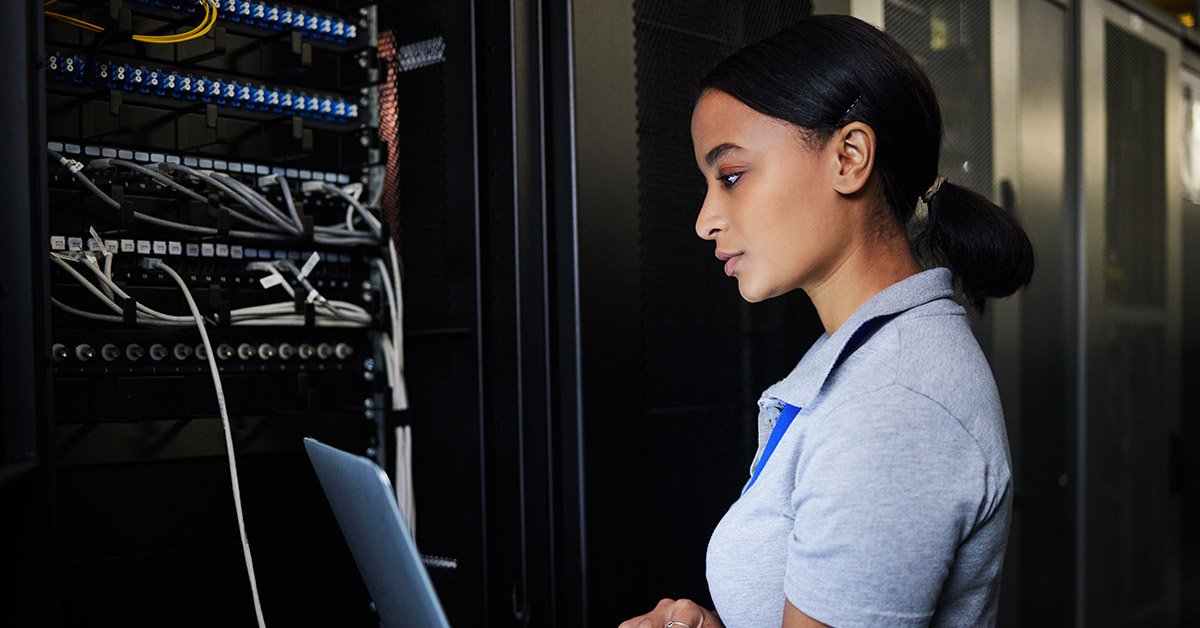 Nainen työskentelee kannettavalla tietokoneella datakeskuksessa. Azure Arc.