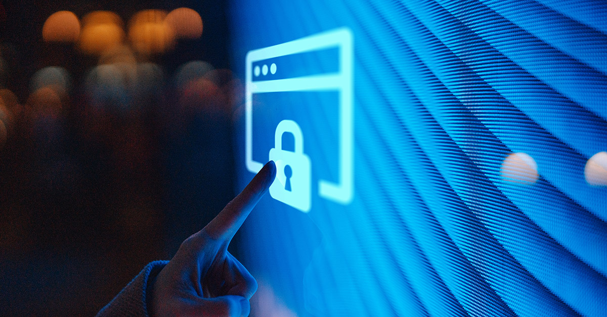 Sormi osoittaa digitaalista näyttöä jossa on lukon kuva. Kyberhyökkäyksien lisääntyminen.