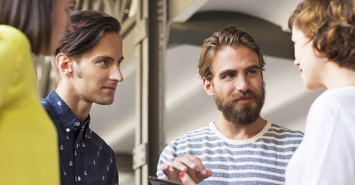 Nainen selittää tiimille asiaa toimistolla tabletin avulla. Yrityksen digitaalinen ilme.