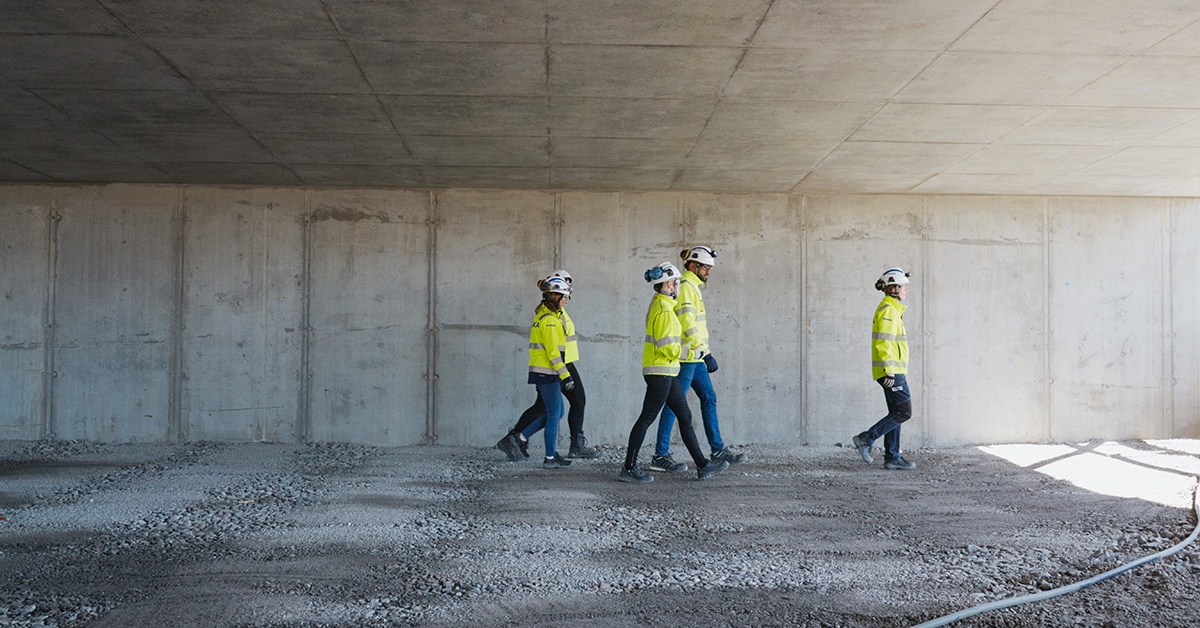 Työntekijät kävelevät rakennustyömaalla. Digitaalisuus rakennustyömaalla.