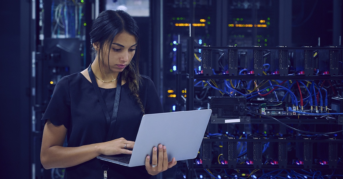 Nainen työskentelee datakeskuksessa. Päästä päähän -kyberturva.