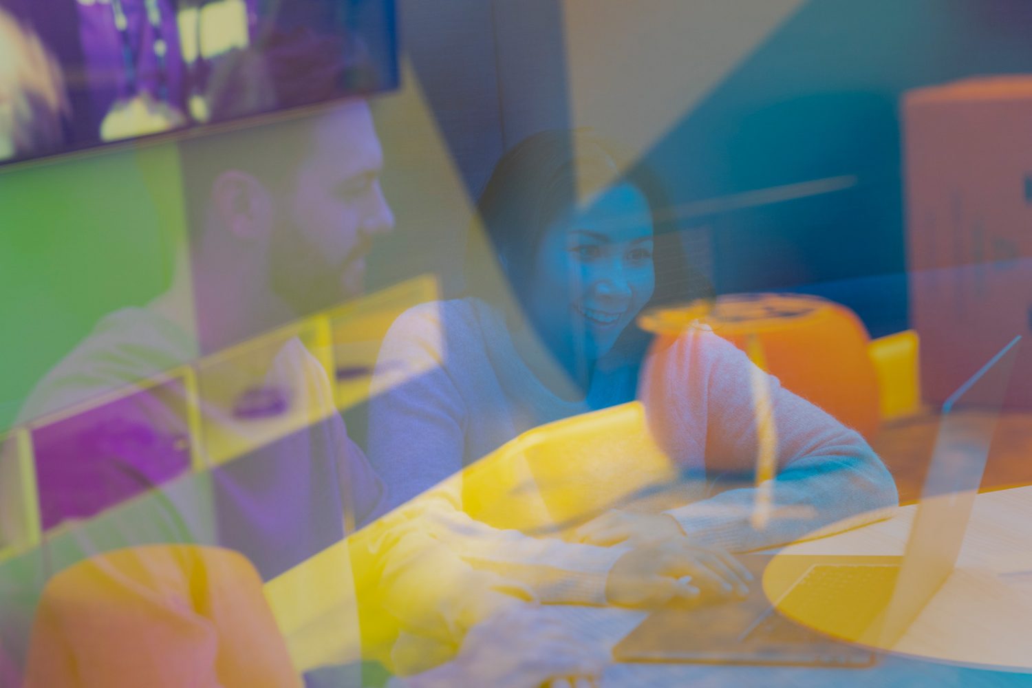 Värikäs kuva, jossa mies ja nainen tietokoneen ääressä