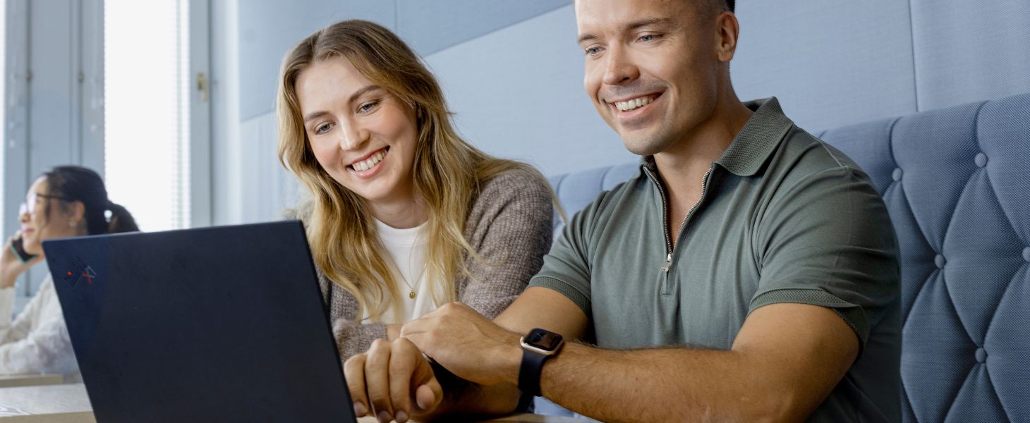 Nainen ja mies katsovat kannettavan tietokoneen ruutua ja tutkivat, kuinka palvelupyyntöjen rikastaminen tekoälyllä toimii.