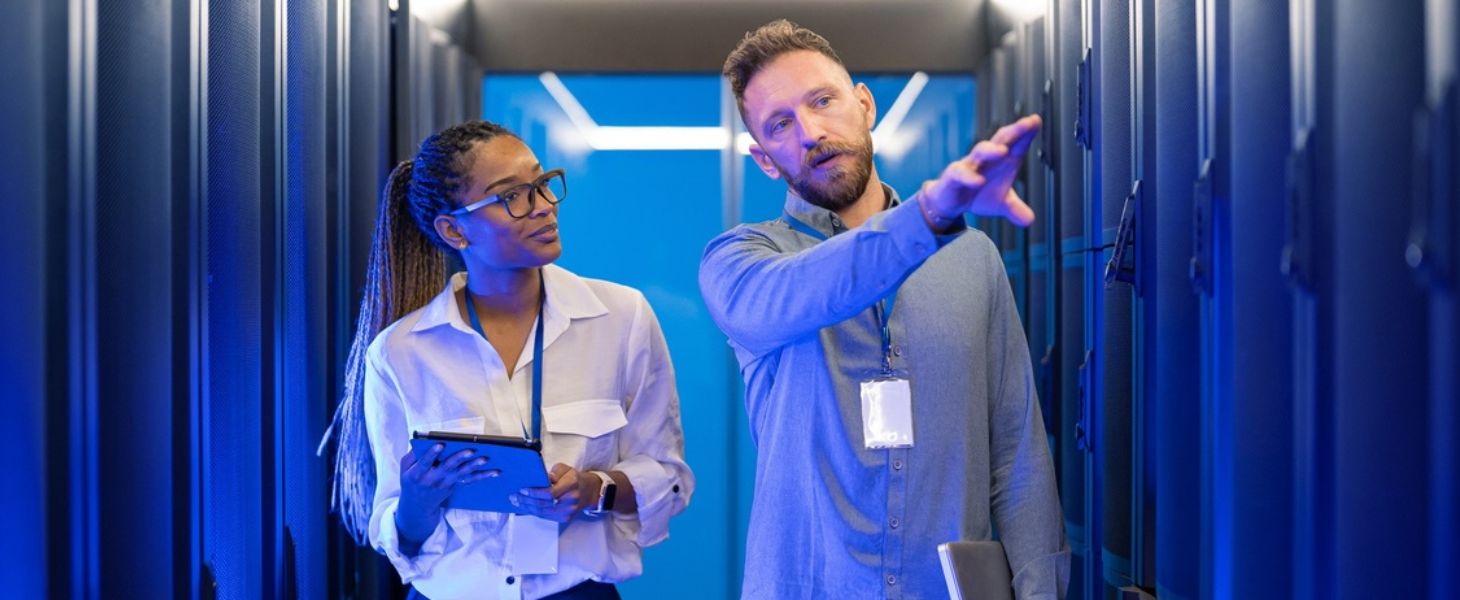 Nainen ja mies keskustelevat sinisen taustan keskellä, miten tekoälykehitys Azurella onnistuu.